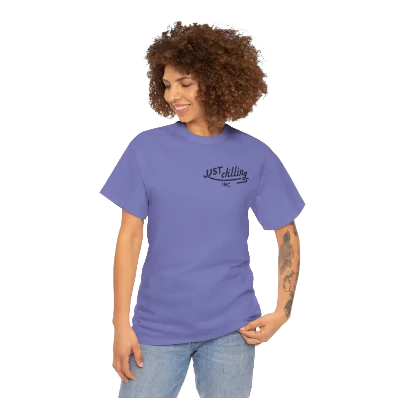 A smiling woman with curly hair wearing a purple t-shirt with the text "Just Chilling Inc." printed on it.