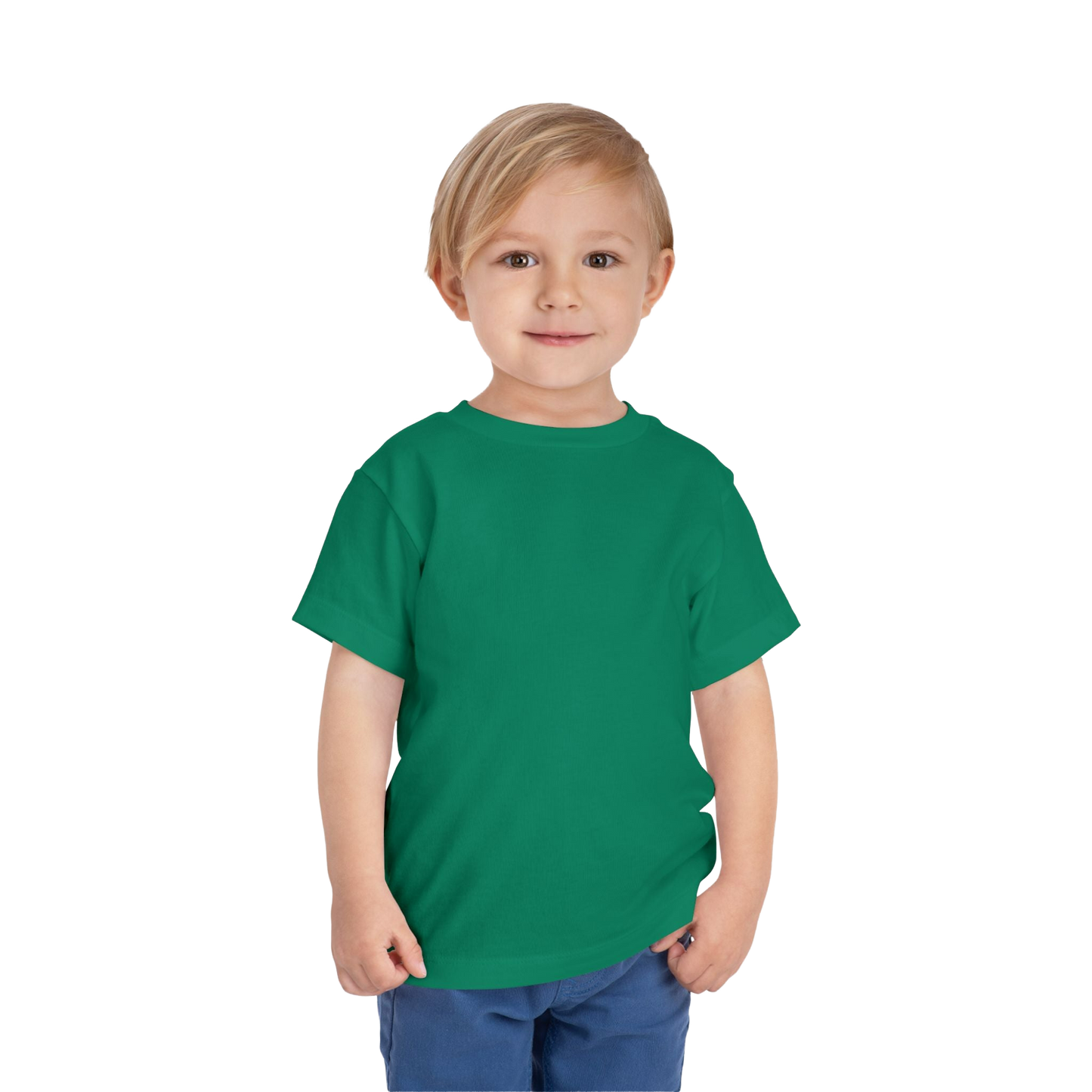 A young boy with blonde hair is wearing a green t-shirt and blue pants, smiling at the camera.