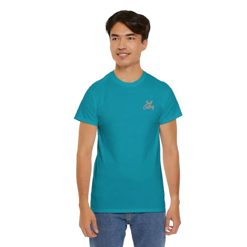 A young man wearing a teal blue t-shirt with a logo on the left side of his chest.