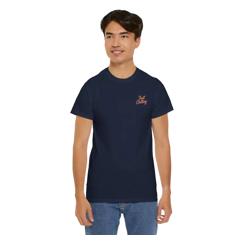 A young man wearing a navy blue t-shirt with a logo on the left side of his chest.