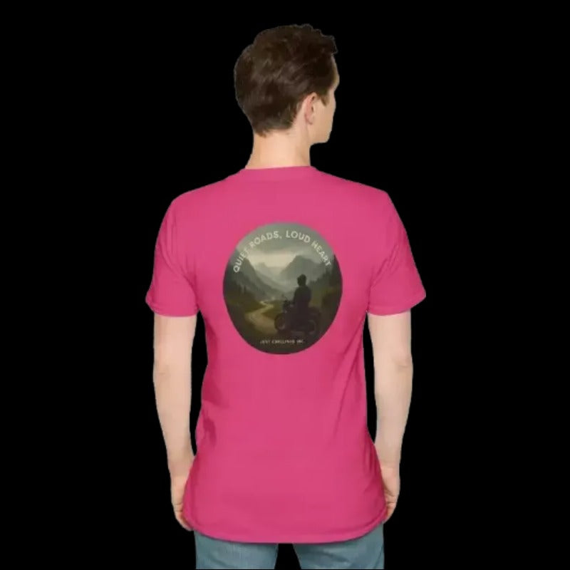A person wearing a pink t-shirt with a graphic design on the back, depicting a person riding a motorcycle on a road with mountains in the background.