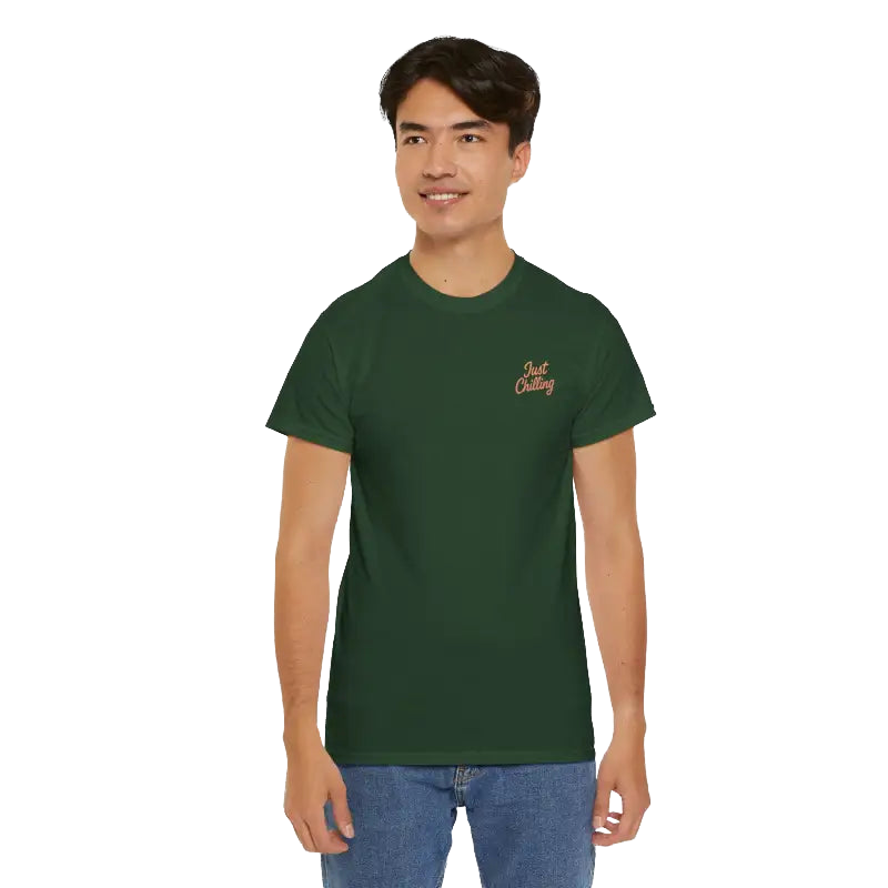 A young man wearing a green t-shirt with a logo on it, smiling at the camera.