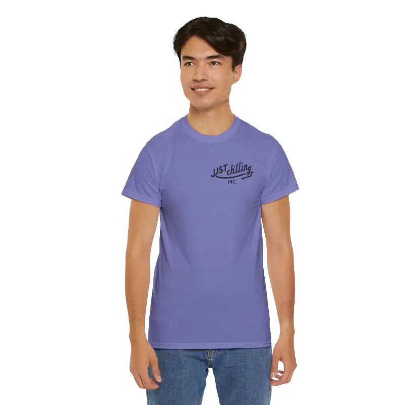 A young man wearing a purple t-shirt with a logo on it, smiling at the camera.