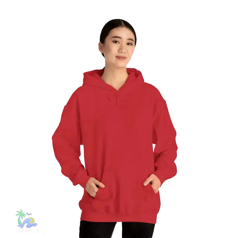 A woman wearing a red hoodie stands against a black background.