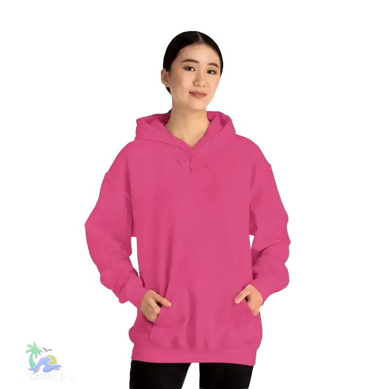 A woman wearing a bright pink hoodie stands against a black background.