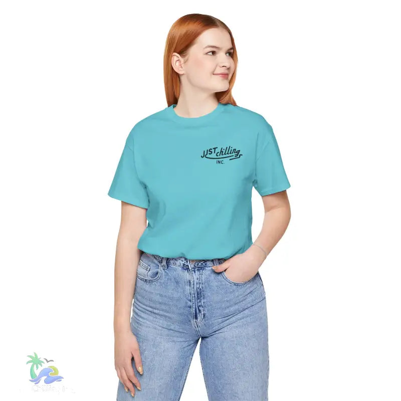 Woman wearing a turquoise t-shirt and jeans.