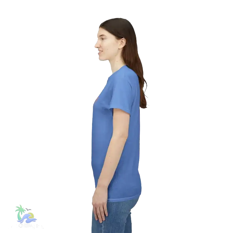 A woman wearing a blue t-shirt and jeans is standing against a black background.