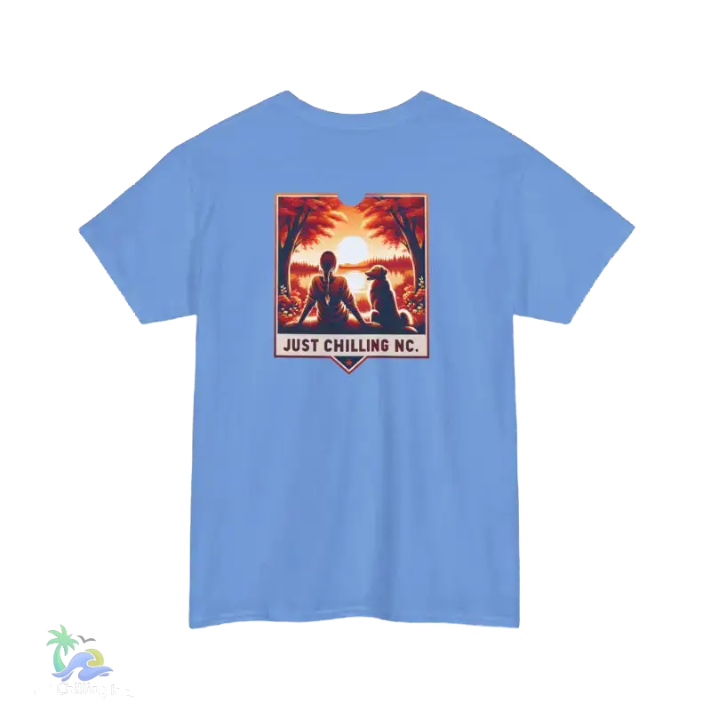 A blue t-shirt with a graphic design depicting two people sitting in a tropical setting, with a sunset in the background. The text below the graphic says "JUST CHILLING MC".