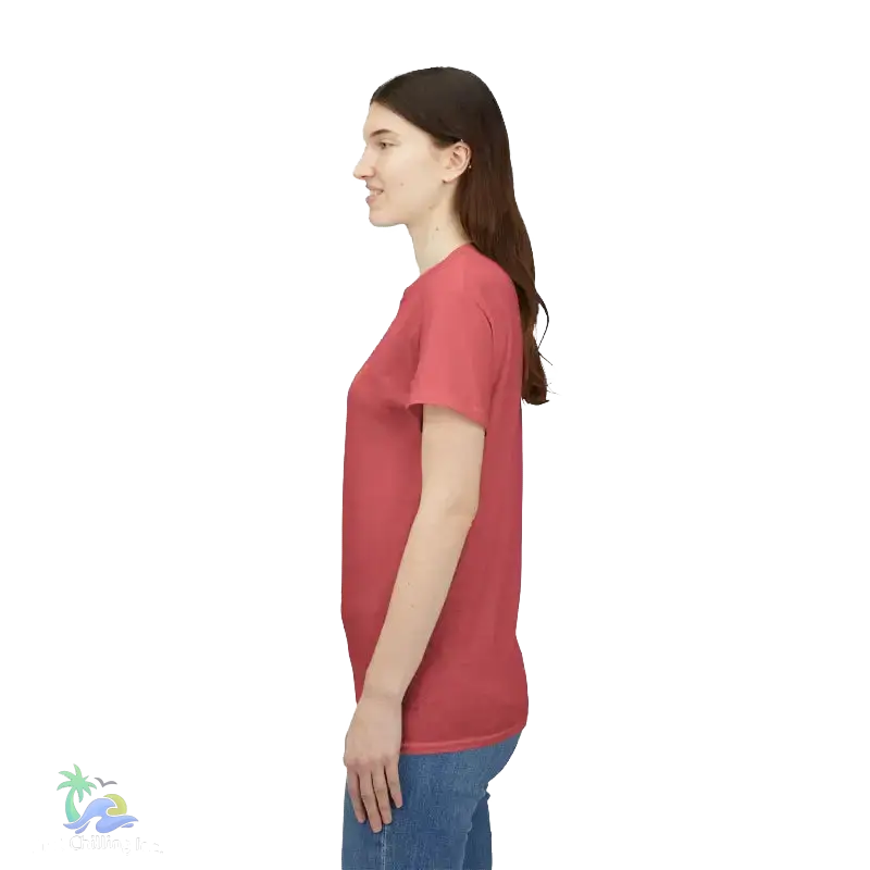 A woman wearing a red t-shirt stands against a black background.