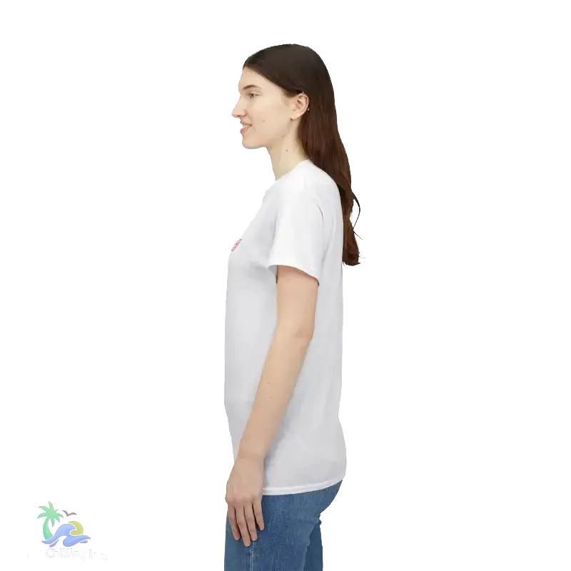 A woman with long brown hair is standing in profile, wearing a white t-shirt and blue jeans.