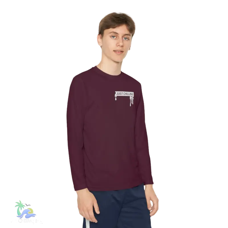 a young man wearing a maroon shirt and blue shorts