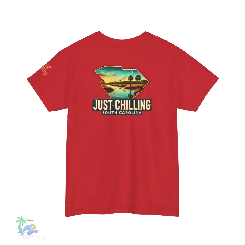 A red t-shirt with a graphic design depicting a scenic landscape, including a lake, mountains, and a sunset. The text on the t-shirt reads "Just Chilling South Carolina".