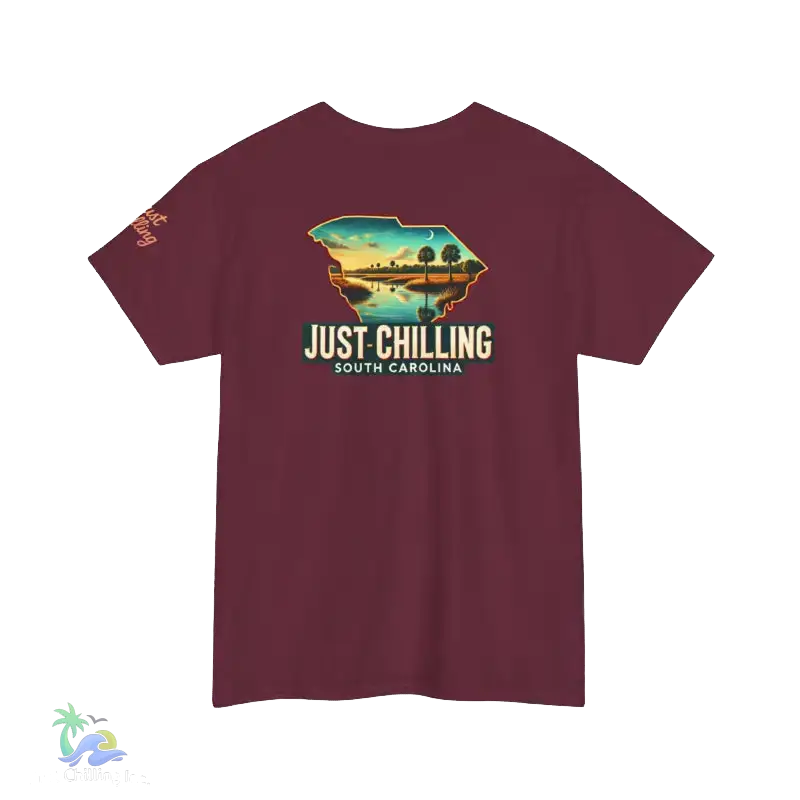 A maroon t-shirt with a graphic design depicting a scenic landscape with a lake and mountains, along with the text "Just Chilling South Carolina" printed on it.