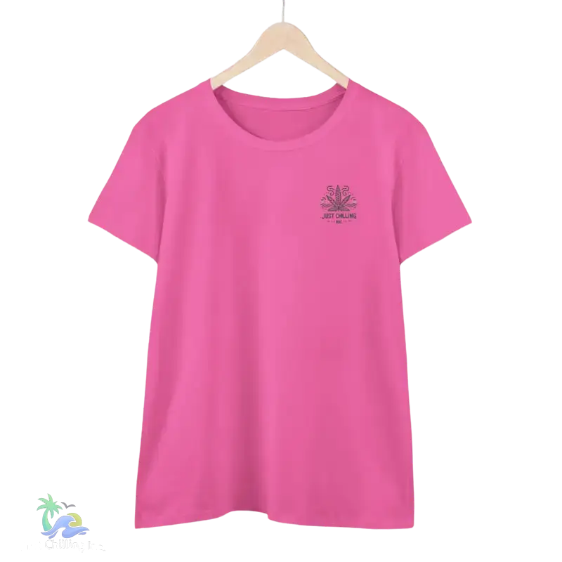 A pink t-shirt with a graphic design on the front, hanging on a wooden hanger against a black background.