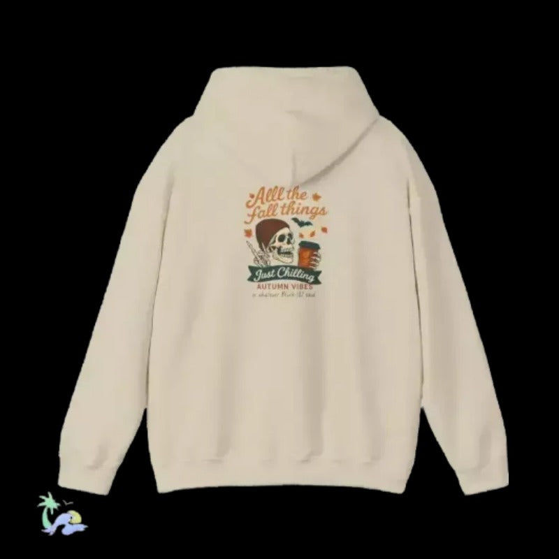 A cream-colored hoodie with a graphic design on the back, featuring a skull and the text "All the things just chilling" along with the phrase "Just chilling" and "as a drink" below.