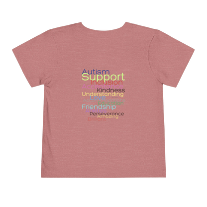 A pink t-shirt with the words "Autism Support" printed on it in a colorful, multicolored font.