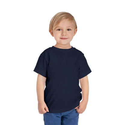 A young boy with blonde hair is smiling and standing against a black background.