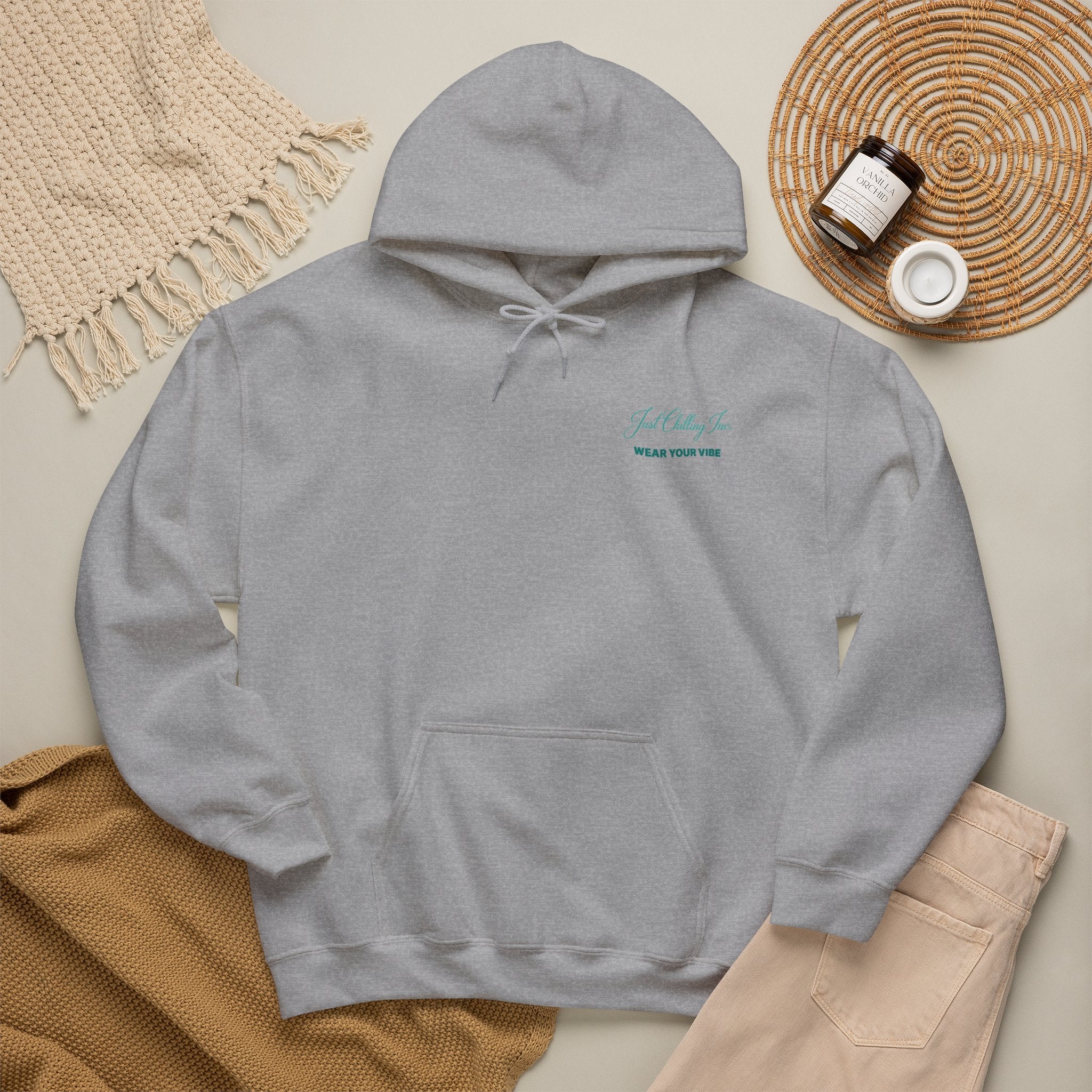 Gray hoodie with 'MONACO' text on a beige surface with accessories.