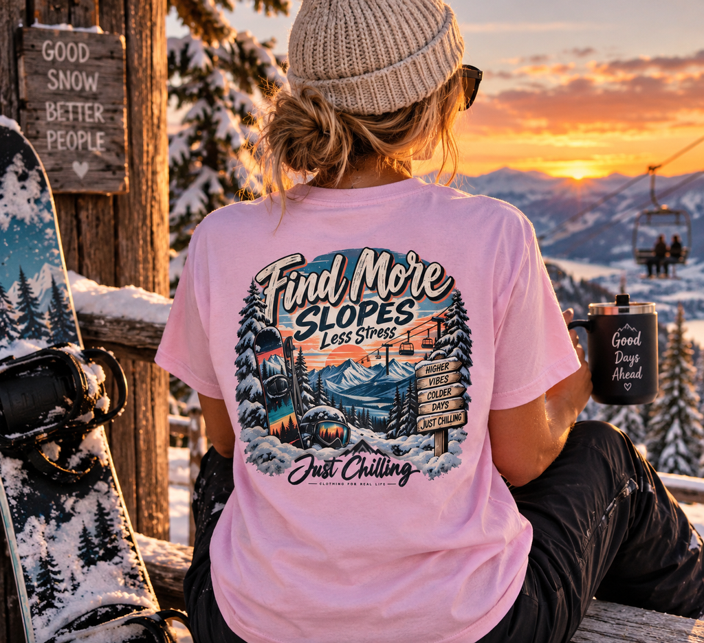 Mujer con camiseta rosa claro de escena invernal sentada al atardecer con taza, tabla de snowboard y letrero rústico
