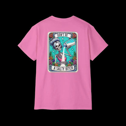 A pink t-shirt with a graphic design featuring a skeleton holding a bottle of alcohol and the text "DON'T BE A SALTY BITCH" against a colorful background.