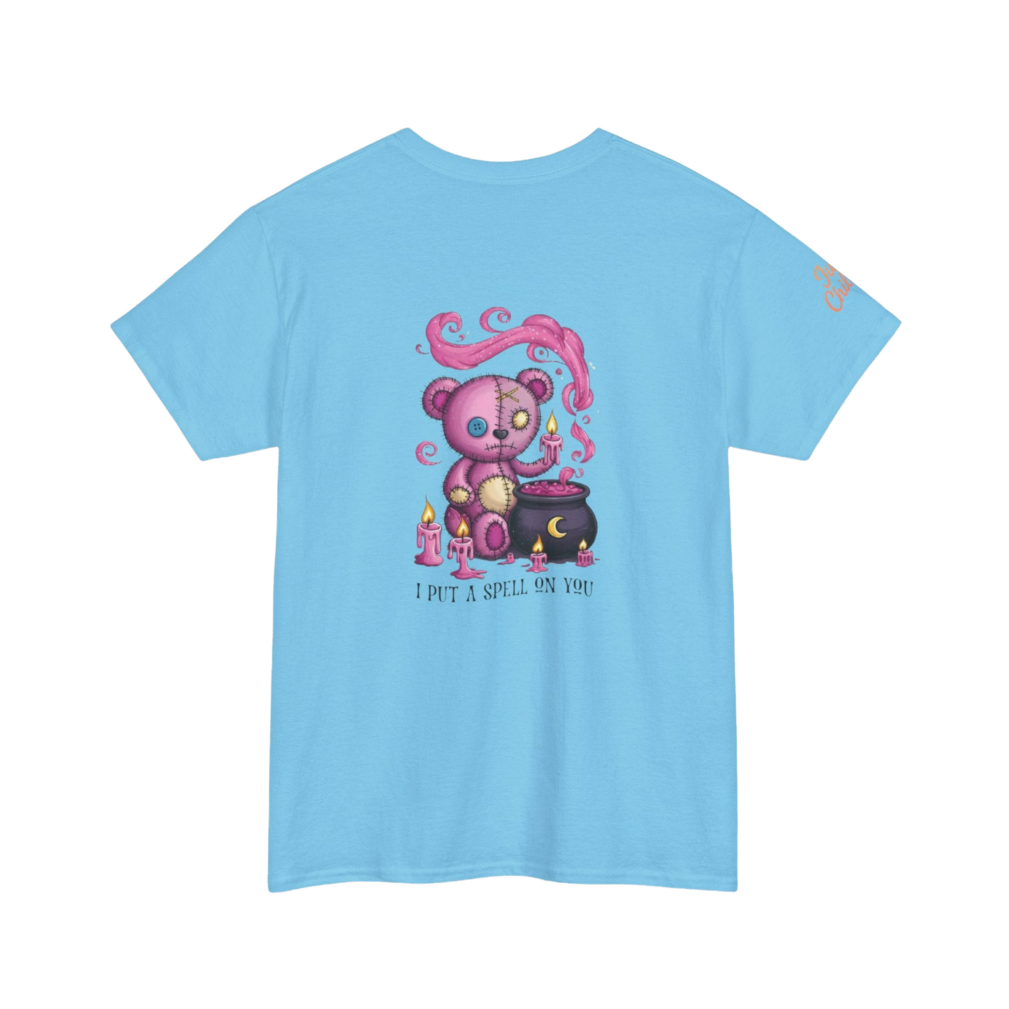A light blue t-shirt with a colorful illustration of a teddy bear surrounded by candles and a cauldron, along with the text "I put a spell on you".