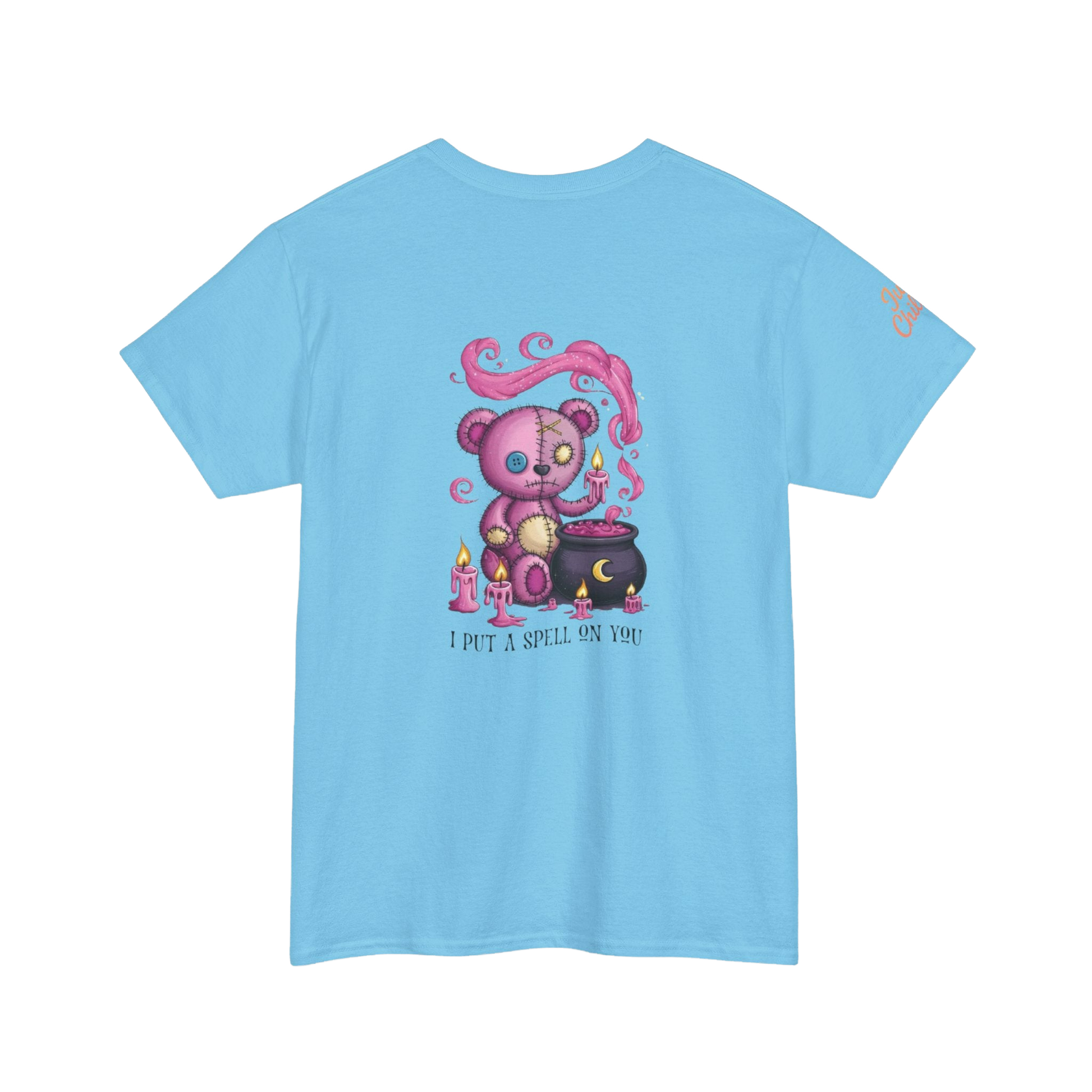 A light blue t-shirt with a colorful illustration of a teddy bear surrounded by candles and a cauldron, along with the text "I put a spell on you".