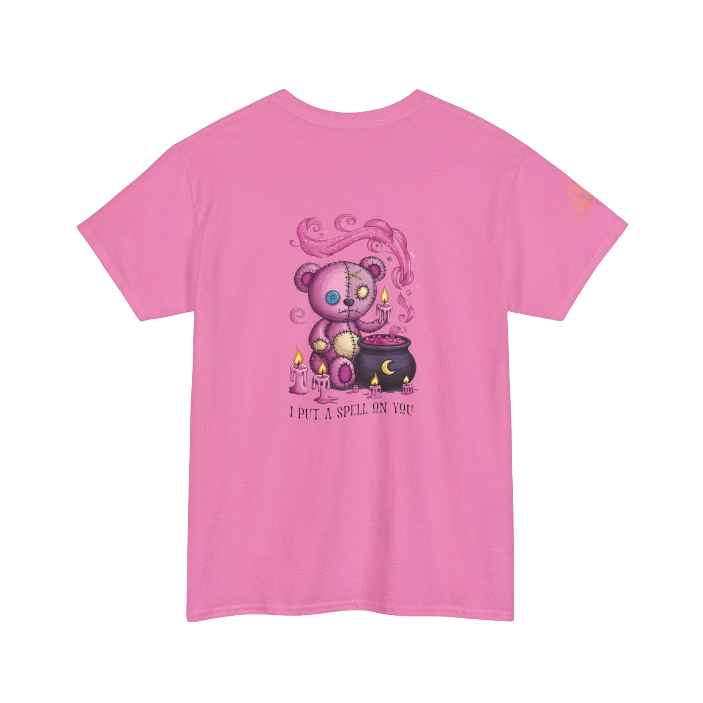 A pink t-shirt with a graphic design depicting a purple teddy bear holding a cauldron and surrounded by flames, with the text "I put a spell on you" below the image.