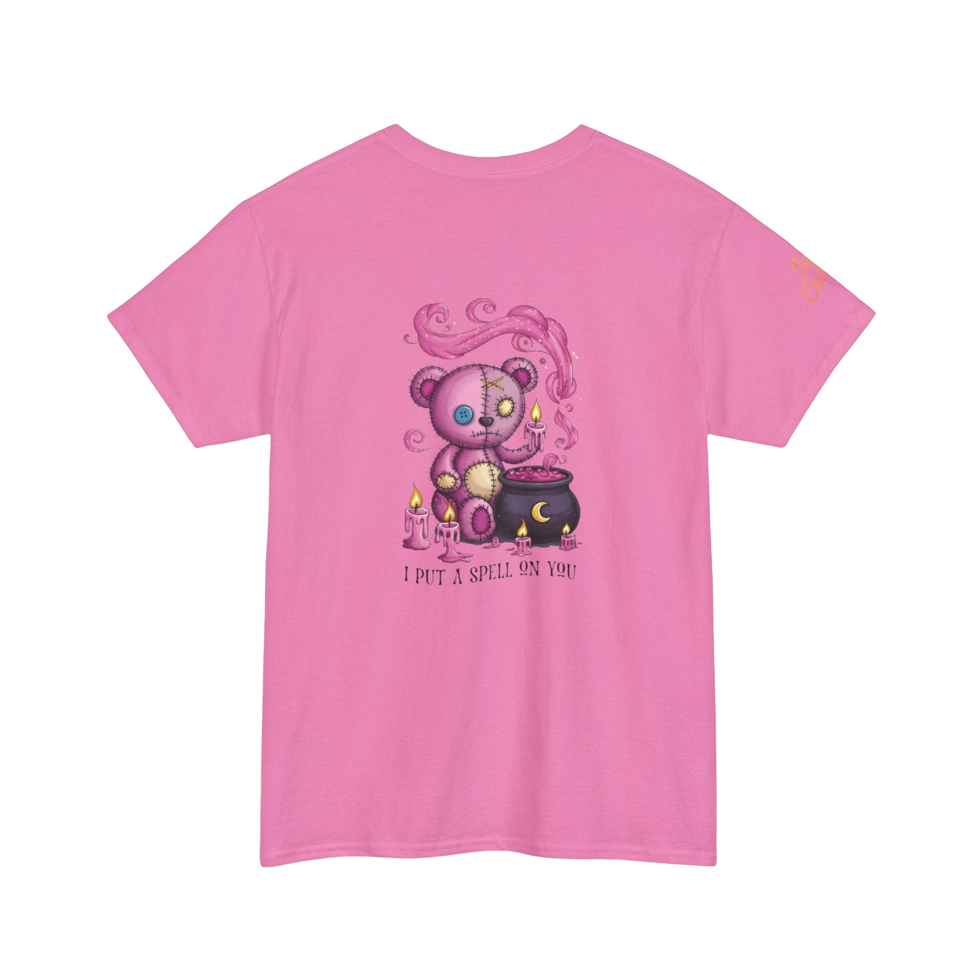 A pink t-shirt with a graphic design depicting a purple teddy bear holding a cauldron and surrounded by flames, with the text "I put a spell on you" below the image.