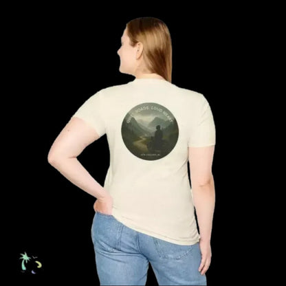 A woman wearing a white t-shirt with a circular design on the back, featuring a silhouette of a person and the text "Quiet Roam Loud Heart".