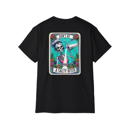 A black t-shirt with a graphic design featuring a skeleton wearing a sombrero and holding a bottle of alcohol, surrounded by colorful flowers and text.
