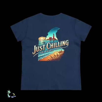 A navy blue t-shirt with a graphic design depicting a beach scene with a lighthouse and a sunset. The text on the t-shirt says "Just Chilling Delaware".