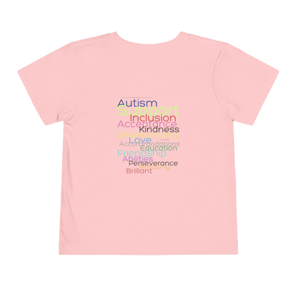 A pink t-shirt with a list of positive traits or characteristics printed on it, including Autism, Inclusion, Kindness, Love, Accompaniments, Education, Perseverance, Brilliance, and others.