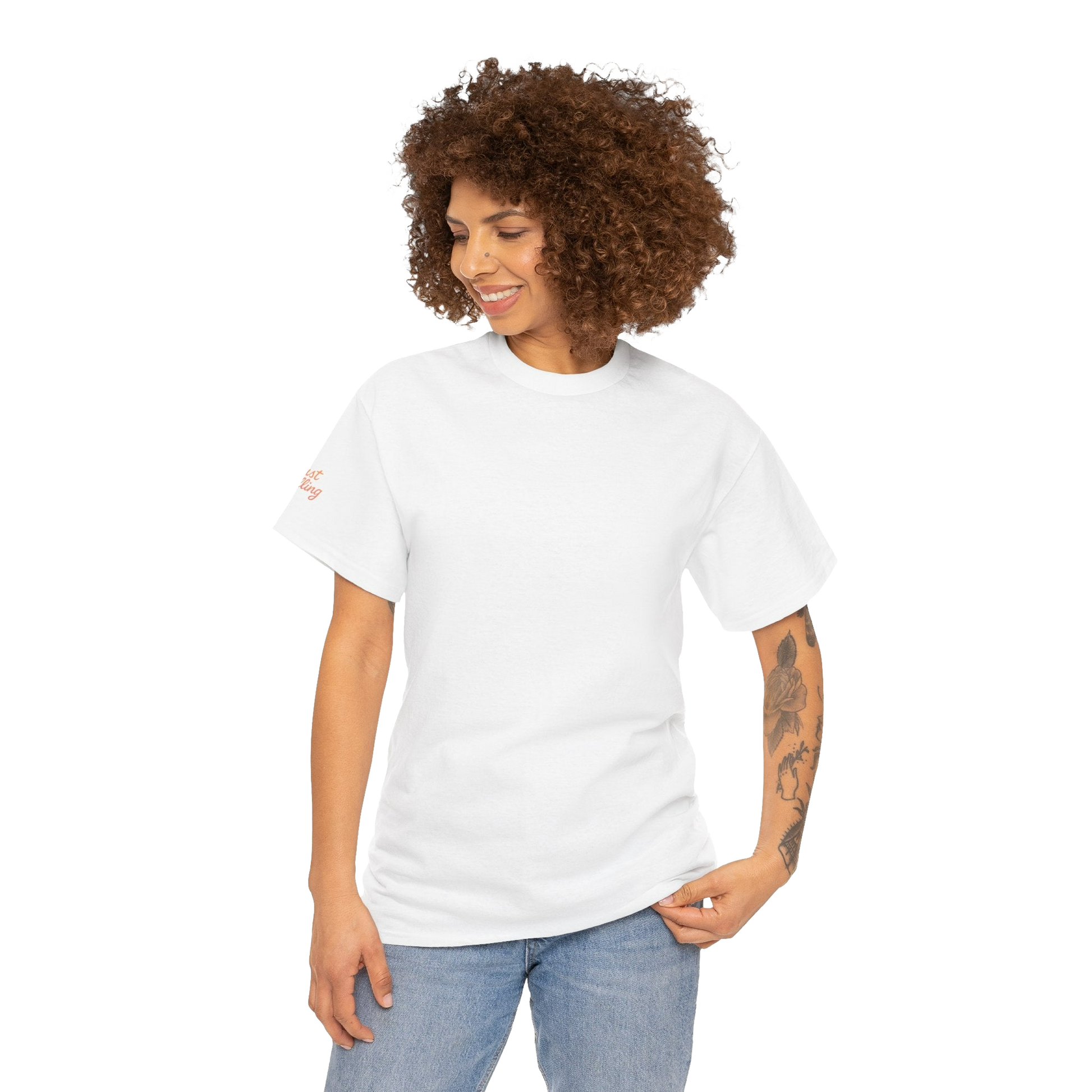 A smiling woman with curly hair wearing a white t-shirt and blue jeans stands against a black background.