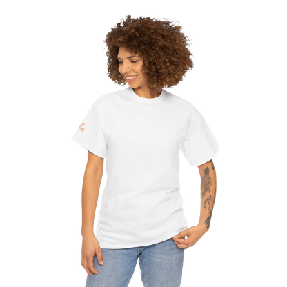 A smiling woman with curly hair wearing a white t-shirt and blue jeans stands against a black background.