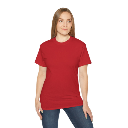 A woman wearing a red t-shirt and jeans stands against a black background.