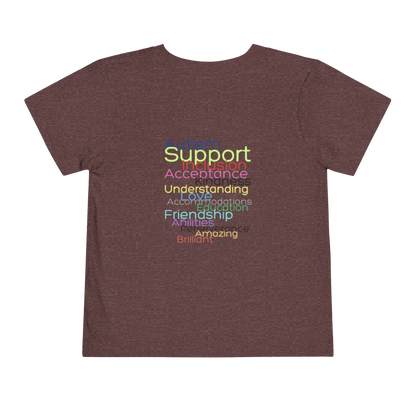 The image is a t-shirt with a graphic design featuring a list of positive attributes or qualities, such as 'Support', 'Acceptance', 'Understanding', 'Friendship', and 'Amazing', all written in a colorful, stylized font.
