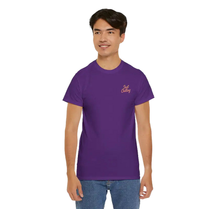 A young man wearing a purple t-shirt with a logo on it, smiling at the camera.