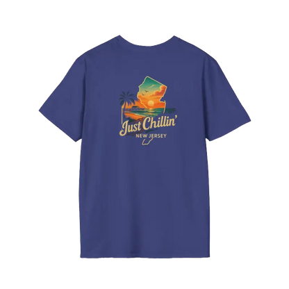 A blue t-shirt with a graphic design depicting a sunset and palm trees, along with the text "Just Chillin' NEW JERSEY".