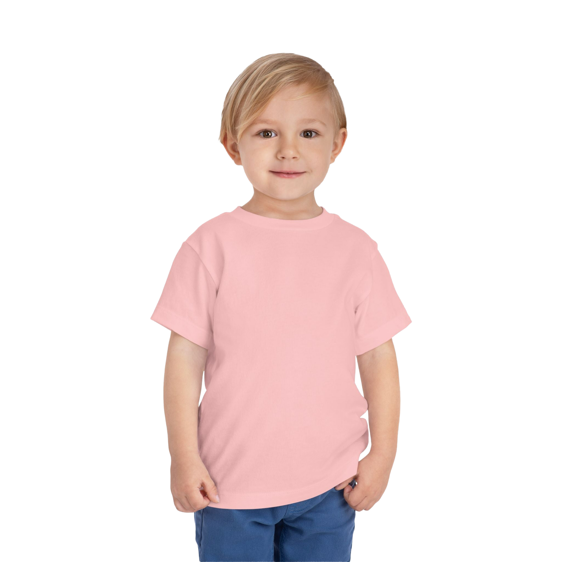 A young child wearing a pink t-shirt and blue pants stands against a black background, smiling at the camera.