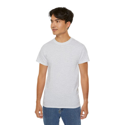 A young man wearing a white t-shirt and blue jeans stands against a black background.
