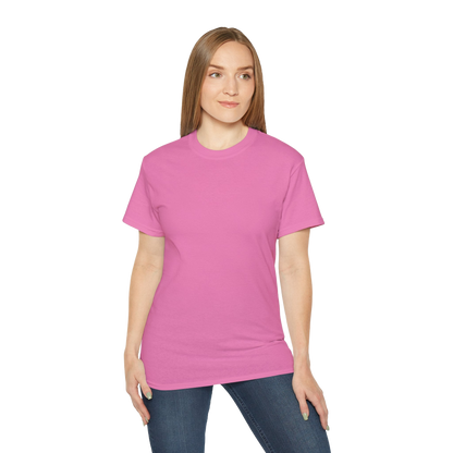 A woman wearing a pink t-shirt and jeans stands against a black background.