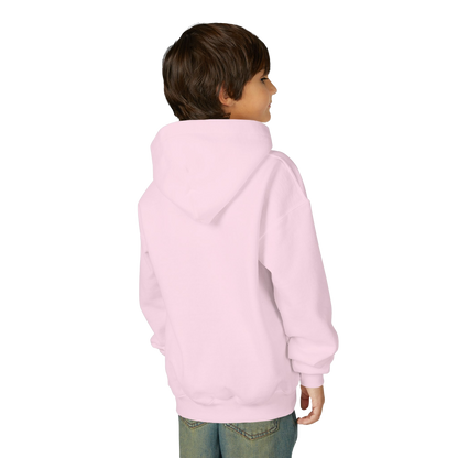 A young boy wearing a pink hoodie stands against a black background, facing away from the camera.