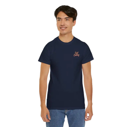 A young man wearing a navy blue t-shirt with a logo on the left side of his chest.