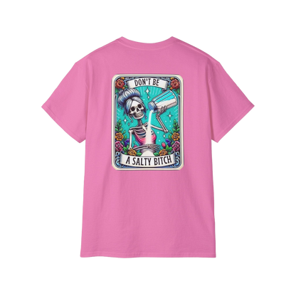 A pink t-shirt with a graphic design featuring a skeleton holding a salt shaker and the text "DON'T BE A SALTY BITCH" against a colorful background.