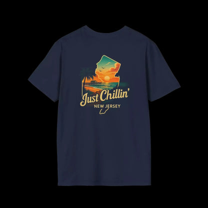 A navy blue t-shirt with a graphic design depicting a sunset over a beach and palm trees, along with the text "Just Chillin' NEW JERSEY".