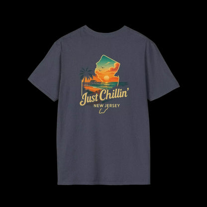 A gray t-shirt with a graphic design depicting a sunset over a beach and palm trees, along with the text "Just Chillin' NEW JERSEY".