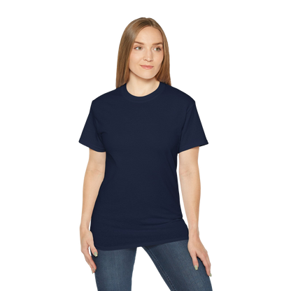 A woman wearing a navy blue t-shirt and jeans stands against a black background.