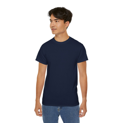 A young man wearing a navy blue t-shirt and blue jeans stands against a black background.