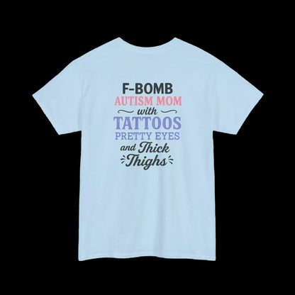 A light blue t-shirt with text that reads "F-BOMB AUTISM MOM with TATTOOES Pretty Eyes and THICK THIGHS" printed on it.