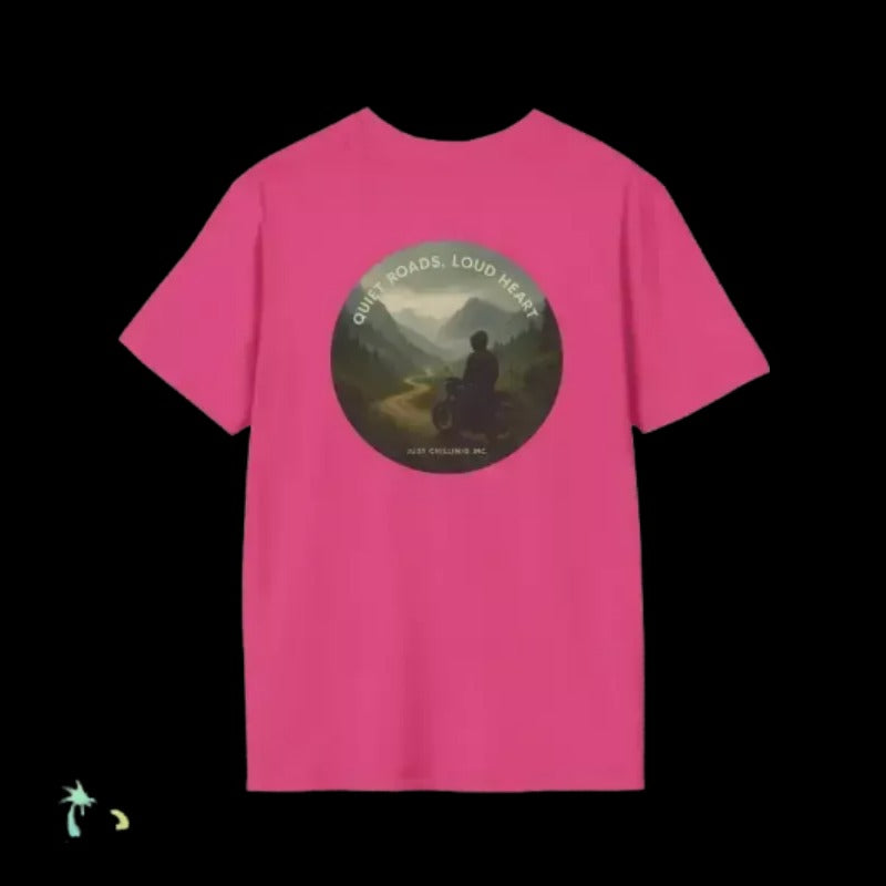 A pink t-shirt with a circular graphic design on it, featuring a person sitting on a motorcycle in a mountainous landscape.